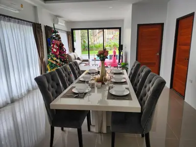 a dining room table with chairs and a christmas tree at PoolVilla 234 Patong in Patong Beach