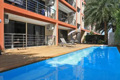 a swimming pool in front of a building at 1bdr Pool Access Apartment Rawai Beach Condominium by Capital Pro in Phuket Town