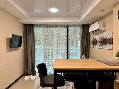 a room with a table and chairs and a window at 1bdr Pool Access Apartment Rawai Beach Condominium by Capital Pro in Phuket Town