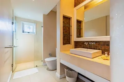 a bathroom with a sink and a toilet and a mirror at 3BR Casa Azul - Beachfront Home in Laguna & Layan Chom Tawan and Maan Tawan Residences in Phuket Town