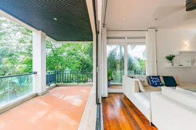 an open living room with a couch and a balcony at 3BR Casa Azul - Beachfront Home in Laguna & Layan Chom Tawan and Maan Tawan Residences in Phuket Town