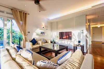a living room with a couch and a tv at 3BR Casa Azul - Beachfront Home in Laguna & Layan Chom Tawan and Maan Tawan Residences in Phuket Town