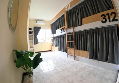 a living room with curtains and a tile floor at KPOP Hostel in Karon Beach