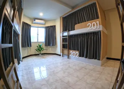 a large room with a stage and curtains at KPOP Hostel in Karon Beach
