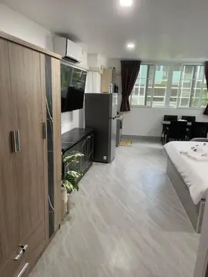 a room with a kitchen with a refrigerator and a table at My Home in Patong Beach