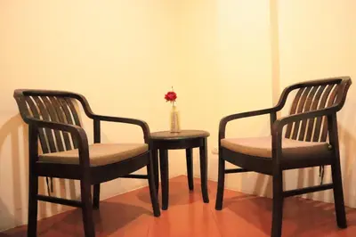 two chairs and a table with a vase on it at Harmony Patong Hotel in Patong Beach
