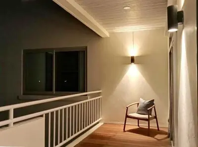 a chair sitting on a balcony with a window at Waterfront Suites Phuket by Centara NEW in Phuket Town