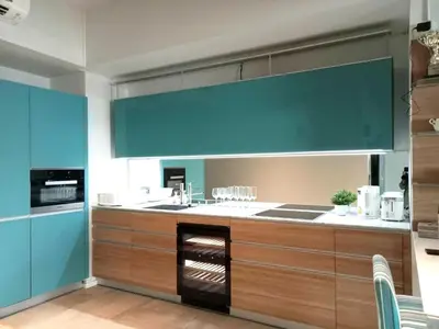 a large kitchen with blue walls and a counter top at Waterfront Suites Phuket by Centara NEW in Phuket Town