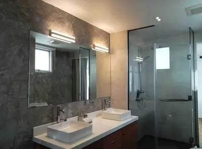 a bathroom with two sinks and a glass shower at Waterfront Suites Phuket by Centara NEW in Phuket Town