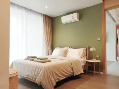a bedroom with a bed with a air conditioner on the wall at Waterfront Suites Phuket by Centara NEW in Phuket Town