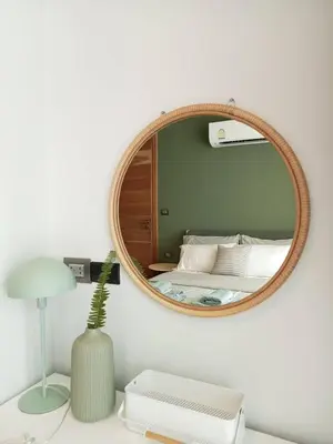 a bedroom with a mirror and a bed and a lamp at Waterfront Suites Phuket by Centara NEW in Phuket Town