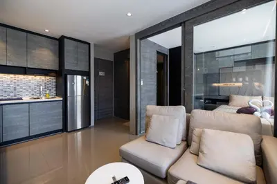 a living room with a couch and a kitchen at Modern Condo in Boutique Style Resort CGB4 in Phuket Town