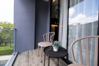 a table and chairs on a balcony with a plant at Modern Condo in Boutique Style Resort CGB4 in Phuket Town