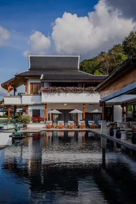 a building with a swimming pool in front of a house at Villa ZeniMo in Phuket Town