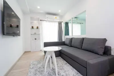 a living room with a couch and a table at Brand New Patong Apartment 1-Bedroom in Patong Beach