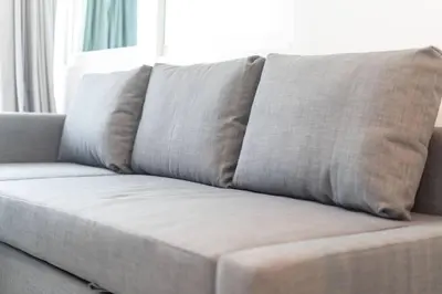 a couch with four pillows on it in a living room at Brand New Patong Apartment 1-Bedroom in Patong Beach
