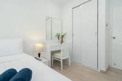 a bedroom with a bed and a desk and a chair at Brand New Patong Apartment 1-Bedroom in Patong Beach
