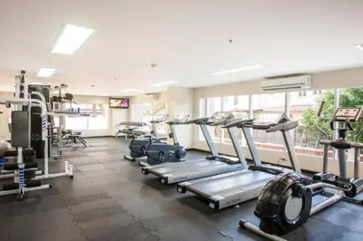 a gym with several tread machines in a room at Brand New Patong Apartment 1-Bedroom in Patong Beach