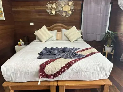 a bed with a blanket on top of it at บ้านสวนปิยนันท์ (Baansuan Piyanan) in Ko Yao Noi