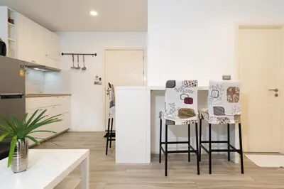 a kitchen with a table and some stools at F11 Title 50м2 Люкс Бассейн Рубль ВАТСАП669З582I976 in Nai Yang Beach