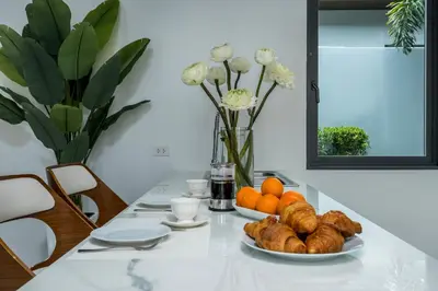 a table with a plate of bread and oranges on it at Two Flamingo Villa 1 in Ban Pak Lak