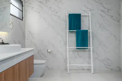 a bathroom with a white toilet and a towel rack at Two Flamingo Villa 1 in Ban Pak Lak
