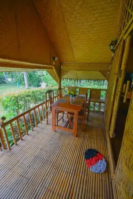 a wooden table on the deck of a house at Ratanaporn Green in Phuket Town