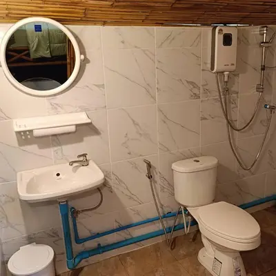 a bathroom with a toilet and a sink and a mirror at Ratanaporn Green in Phuket Town