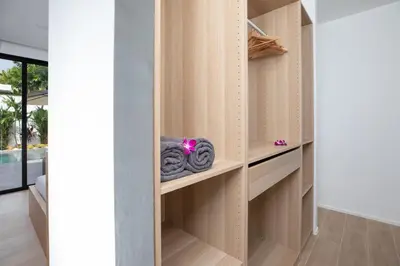 a dressing room with wooden shelves with towels at Mango Hill Residence in Rawai Beach