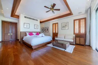 a bedroom with a bed and a ceiling fan at Seaview 5BR Pool Villa Apsara, Free Breakfast and Full Service, 5 min walk to Kata Beach in Kata Beach