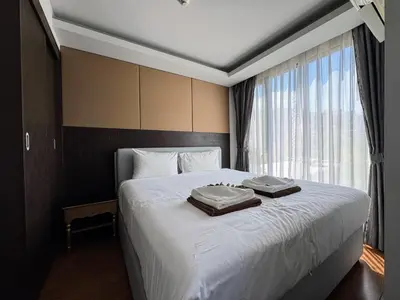 a hotel room with a bed with two towels on it at Aristo 1 Apartments by Beringela in Surin Beach