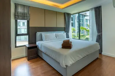 a bedroom with a large bed with a window at Aristo 1 Apartments by Beringela in Surin Beach