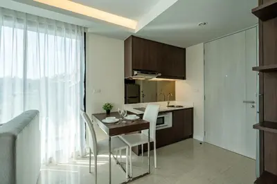 a kitchen with a table and chairs in a room at Aristo 1 Apartments by Beringela in Surin Beach
