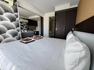 a bedroom with a large white bed with two plates on it at Aristo 1 Apartments by Beringela in Surin Beach