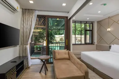 a hotel room with a bed and a couch at The Proud Karon Beach Phuket Trademark Collection By Wyndham in Karon Beach