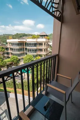 a balcony with a chair and a view of a building at The Proud Karon Beach Phuket Trademark Collection By Wyndham in Karon Beach