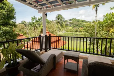 a balcony with chairs and a view of a lake at Grand 4-Bed Lagoon Villa - Private Pool & Garden - Laguna in Ban Thalat Choeng Thale