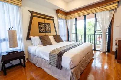 a bedroom with a bed and a balcony with windows at Grand 4-Bed Lagoon Villa - Private Pool & Garden - Laguna in Ban Thalat Choeng Thale