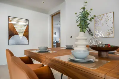 a dining room with a wooden table with chairs at Space villa Botanica Modern Loft in Ban Pak Lak
