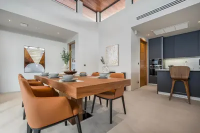 a kitchen and dining room with a wooden table and chairs at Space villa Botanica Modern Loft in Ban Pak Lak