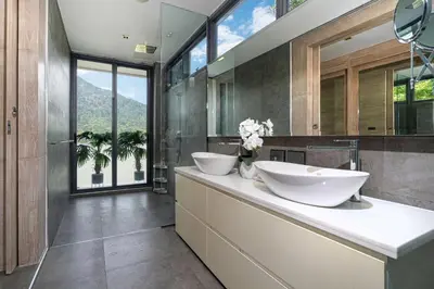 a bathroom with two sinks on a counter with windows at Serenity and Modern Art - Open Hill View 3BR Natural Park Villa 1 in Kamala Beach