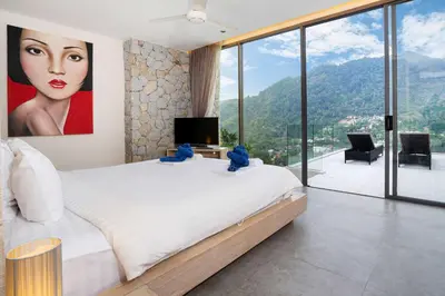 a bedroom with a large painting of a woman on the wall at Serenity and Modern Art - Open Hill View 3BR Natural Park Villa 1 in Kamala Beach