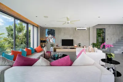 a living room with a white couch with colorful pillows at Serenity and Modern Art - Open Hill View 3BR Natural Park Villa 1 in Kamala Beach