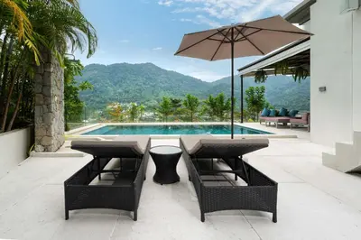 a patio with a table and an umbrella and a pool at Serenity and Modern Art - Open Hill View 3BR Natural Park Villa 1 in Kamala Beach