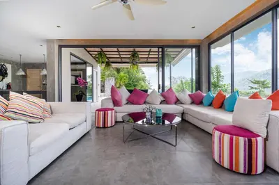 a living room with a white couch with colorful pillows at Serenity and Modern Art - Open Hill View 3BR Natural Park Villa 1 in Kamala Beach