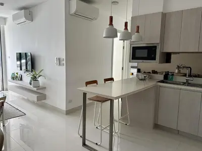 a white kitchen with a table and chairs in it at 2 bedroom Condo at Cassia Laguna in Bang Tao Beach