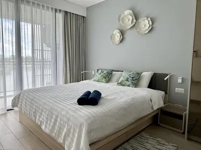 a bedroom with a bed with two blue pillows at 2 bedroom Condo at Cassia Laguna in Bang Tao Beach