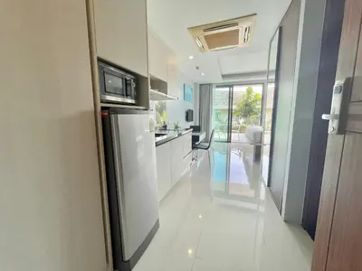 a kitchen with a refrigerator and a counter top at 1 bedroom near beach - At The Tree in Rawai Beach