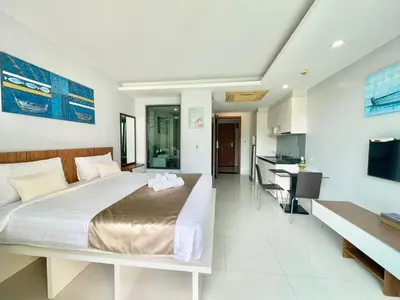 a bedroom with a large bed and a kitchen at 1 bedroom near beach - At The Tree in Rawai Beach