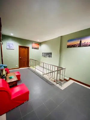 a living room with a red couch and a staircase at BT hotel Kata Beach in Kata Beach
